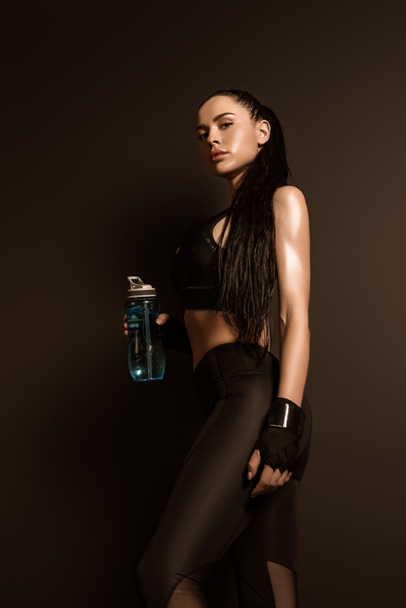 Alacsony látószögű kilátás sportos nő sport palack nézi kamera fekete - Fotó, kép
