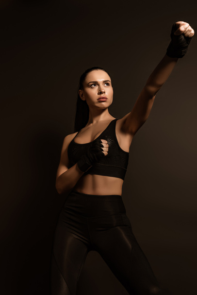 Gyönyörű sportos nő nyitott kézzel sportkesztyűben elszigetelt fekete - Fotó, kép