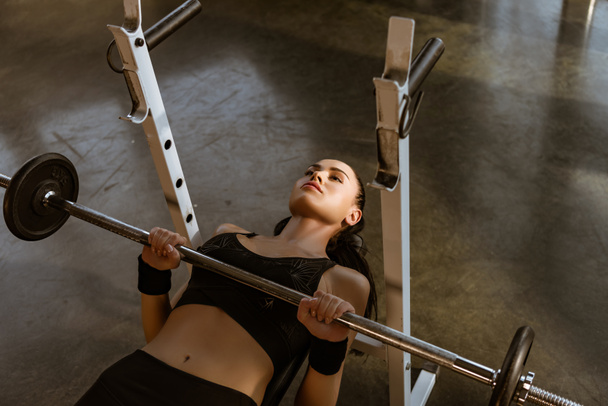 High angle view of sportswoman training with barbell in gym - Photo, Image
