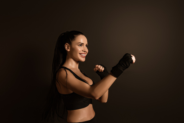 Sportasszony mosolyog és áll harci helyzetben elszigetelt fekete - Fotó, kép
