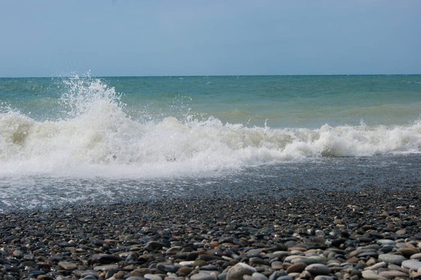 A tenger aggódik egyszer - egy kis sáros víz a Fekete-tenger után egy kis vihar. A tenger, tiszta ég és sima horizont vonal, hullám, nedves nagy kavicsok a strandon. - Fotó, kép