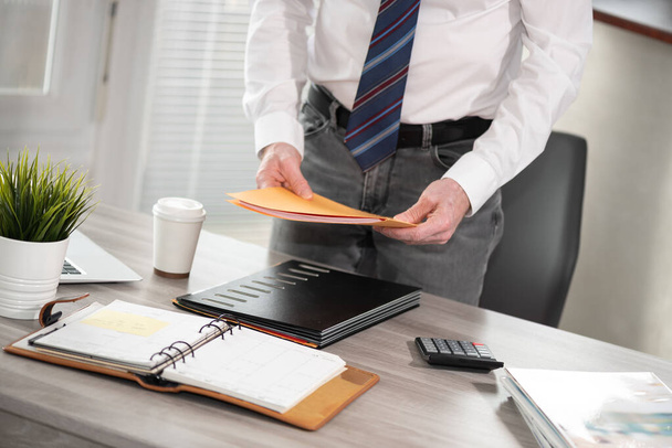 Businessman holding folder with paper documents - Photo, Image