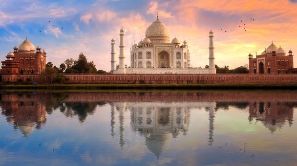 Taj Mahal historyczny biały marmur pomnik o zachodzie słońca z odbiciem wody na rzece Yamuna w Agra, Indie - Zdjęcie, obraz