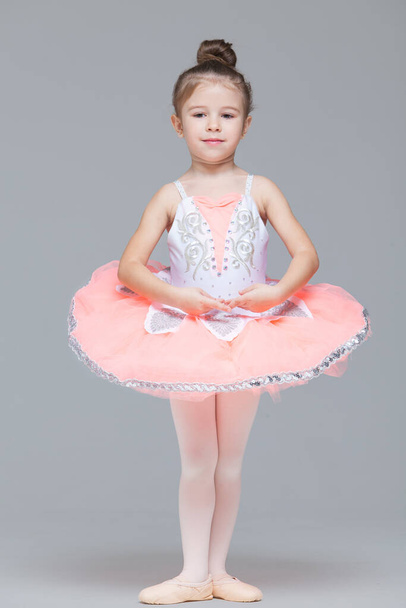 Cute adorable ballerina little girl in pink tutu dance practices ballet dancing - 写真・画像