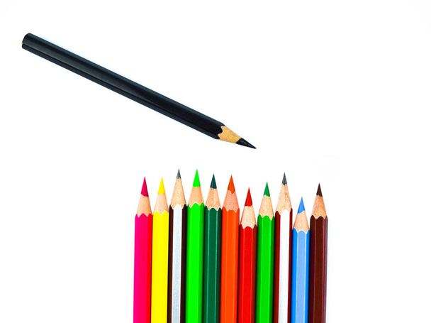 A black colored wood pencil crayons placed over a row of different color wood pencil crayons - Fotografie, Obrázek