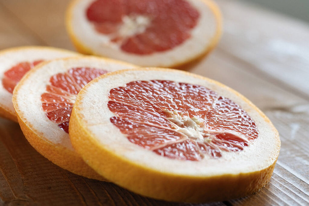 Sliced grapefruit on a table - Fotoğraf, Görsel