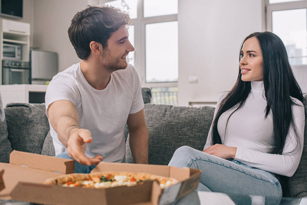 hermosa pareja teniendo pizza durante auto aislamiento en casa
  - Foto, Imagen