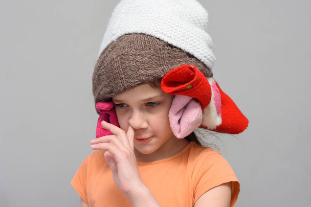 Menina escolhendo seu nariz com um chapéu engraçado caseiro
 - Foto, Imagem