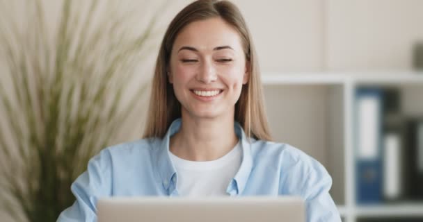 Smiling young woman using laptop at home - Felvétel, videó