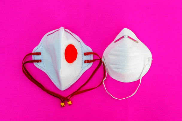 Bílá lékařská maska izolované na růžovém pozadí.Zdravotní péče a lékařské koncepce - Fotografie, Obrázek