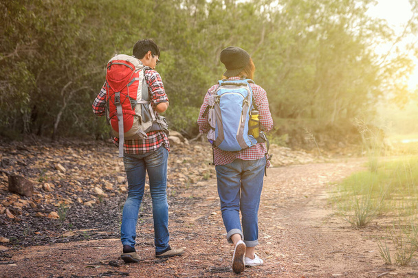 Man and woman walking along have backpack for hiking. Camper camping / hiking / tour / travel. Have a romantic atmosphere / relaxation. The concept of camping and hiking. - Photo, Image