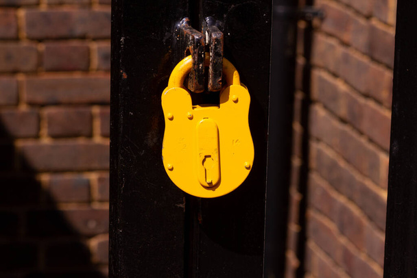 Sarı güvenlik kilidi metal bir mandalı kilitliyor - Fotoğraf, Görsel