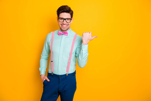 Portrait of positive guy point forefinger copyspace indicate advert promotion recommend pick tips wear blue bowtie isolated over bright shine color background - Foto, Imagem