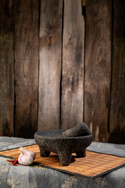 Traditional molcajete to make Mexican sauce with vegetables, on rustic wooden background. Chili, garlic. - Zdjęcie, obraz