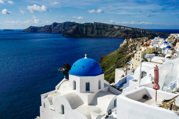 blue-domed church near white houses and sea in Santorini  - Photo, Image