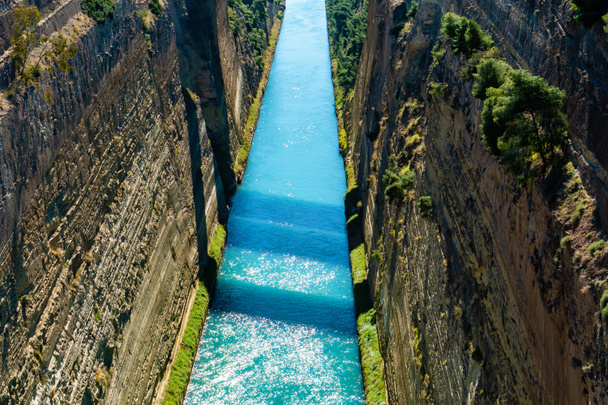 agua azul que fluye cerca de colinas rocosas con moho
  - Foto, imagen