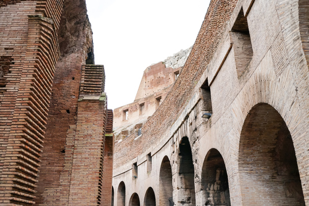 low angle view of historical walls of colosseum against cloudy sky  - Foto, afbeelding