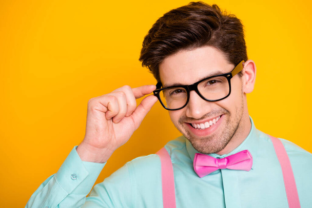 Closeup photo of handsome cool clothes guy beaming smile touch hand hold eyesight care specs wear shirt suspenders bow tie isolated bright yellow color background - Fotografie, Obrázek