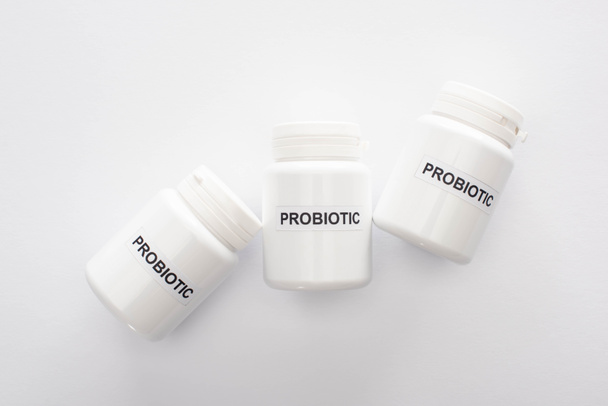 top view of containers with probiotic lettering on white background - Фото, зображення