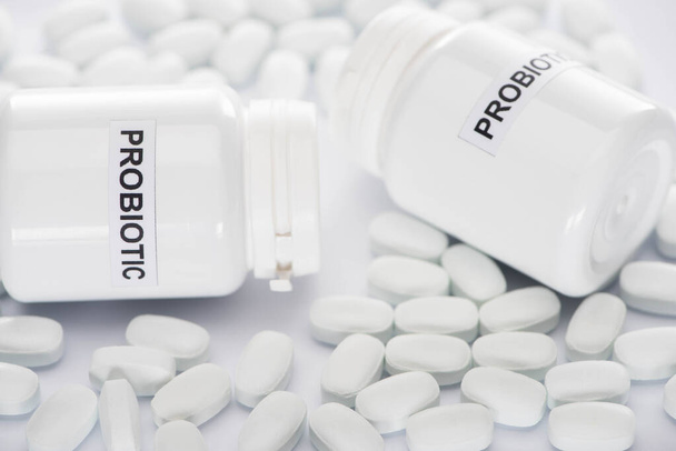 Selektive Fokussierung probiotischer Behälter und Pillen auf weißem Hintergrund - Foto, Bild