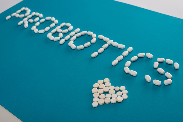 napisy probiotyków i serce wykonane z tabletek na niebiesko-białym tle - Zdjęcie, obraz