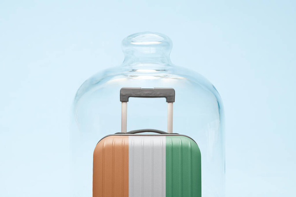 Suitcase with Ivory Coast flag design in quarantine minimal creative coronavirus travel restriction concept. - Фото, изображение