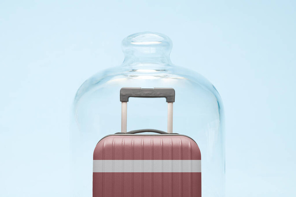 Suitcase with Latvian flag design in quarantine minimal creative coronavirus travel restriction concept. - Valokuva, kuva