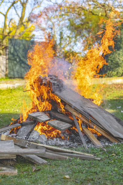 Ardiendo leña, brasa y troncos en llamas. Fuego de campamento en el jardín
. - Foto, imagen