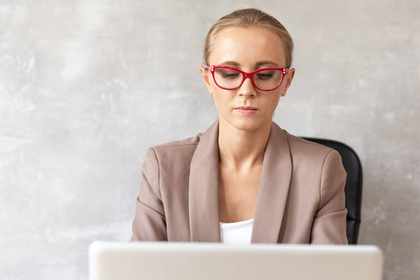 Blond woman in glasses working with lapatop. Office worker - Foto, immagini