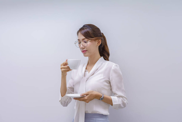 Ritratto di un'impiegata che mangia caffè su sfondo bianco
 - Foto, immagini