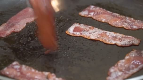 Crujiente frito caliente de trozos de tocino siendo frito en una sartén
 - Metraje, vídeo