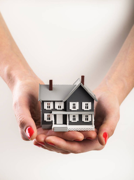 Woman holds a home building in her hands - Photo, image