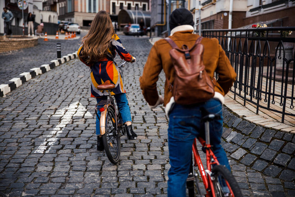 Two people having bike ride in the city on stone road - Фото, зображення