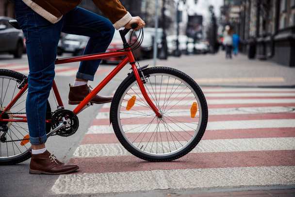 Cycler waiting on the pedestrian crossing to continue his trip - 写真・画像