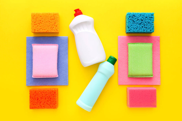 Colorful cleaning set for different surfaces in kitchen on yellow background. Top view, flat lay - Valokuva, kuva