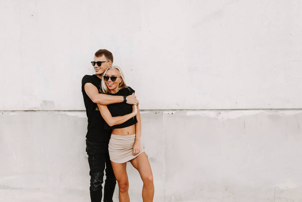 Lovely couple spending time holding hands with intimate emotion. Street fashion photography outdoor in white background available space for text for advertisement. - Fotó, kép