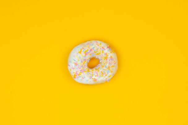 Doce donut branco no fundo amarelo. Comida de sobremesa
 - Foto, Imagem