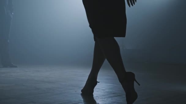 Legs of tango dancers in dark smoky studio. Woman goes to man. Legs on heels. - 映像、動画