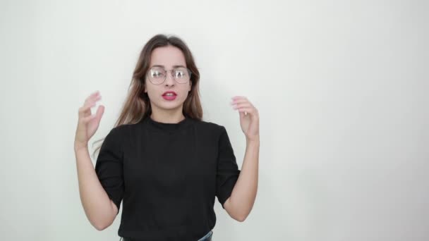 verward meisje met bril geplaatst haar handen breed in verrassing - Video