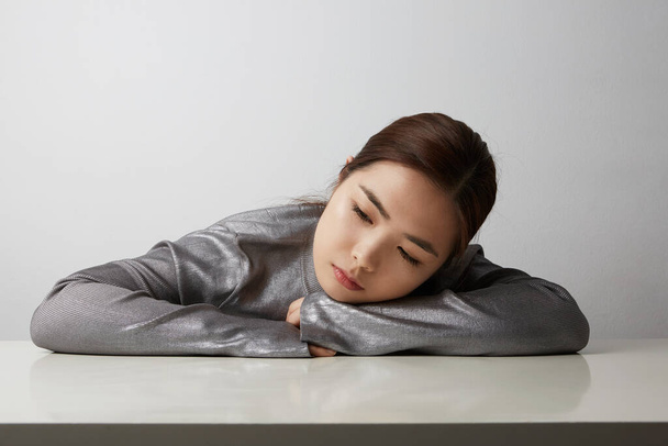 Young asian woman sleeping on the white table. Relaxing concept. Space for your text. - Foto, Bild