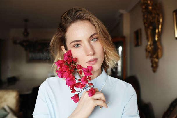 Young woman have a good mood and wearing blue shirt and holding wildflowers. - Photo, Image
