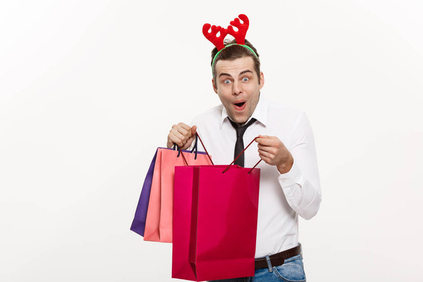 Χριστούγεννα Concept - Όμορφος επιχειρηματίας γιορτάσουν Καλά Χριστούγεννα και ευτυχισμένο το νέο έτος φορούν ταράνδων hairband και κρατώντας Σάντα κόκκινο μεγάλη τσάντα. - Φωτογραφία, εικόνα