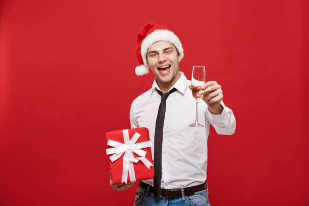Kerstconcept - portret gelukkig Kerstman zakenman spannend met zijn geschenk over rode achtergrond. - Foto, afbeelding