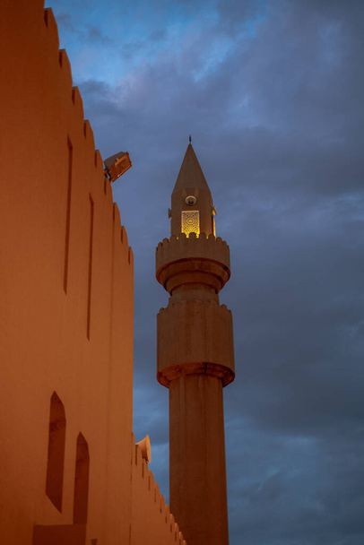 Minarete de mezquita musulmana con nube oscura durante el día lluvioso en Qatar - Foto, imagen