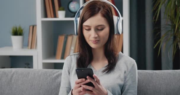 Happy woman listening music in wireless headphones - Metraje, vídeo