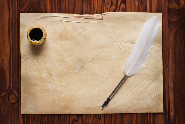 Carta antica, penna bianca e calamaio su legno
 - Foto, immagini