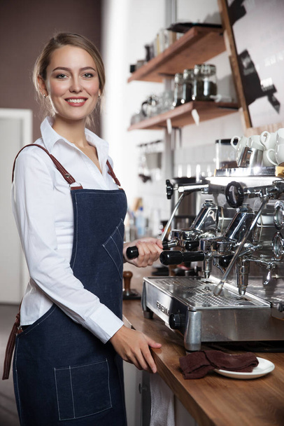  young barista girl makes coffee - Fotó, kép
