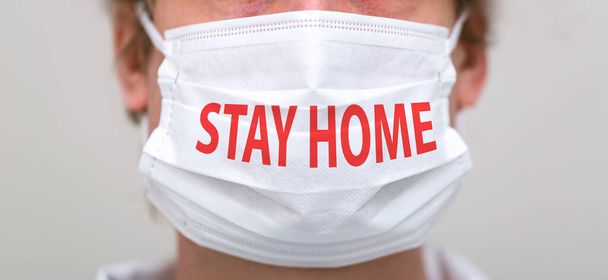 Stay home theme with person wearing a protective face mask - Photo, Image