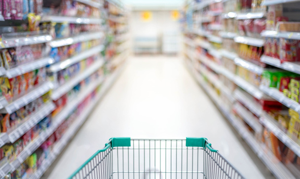 Efecto borroso en el pasillo del supermercado con plata vacía y carrito de compras verde, Comprador elegir la comida en el supermercado comprador de pánico para acaparar alimentos, Coronavirus Covid-19 concepto
. - Foto, Imagen