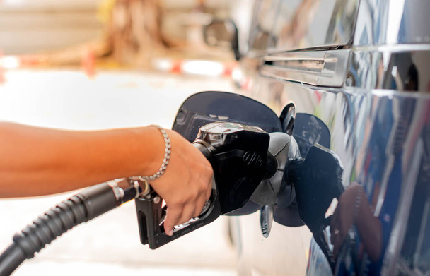 Мужской ручной заправки бензобака бензина бензина бензина в автомобиле заполняется топливом на АЗС
. - Фото, изображение
